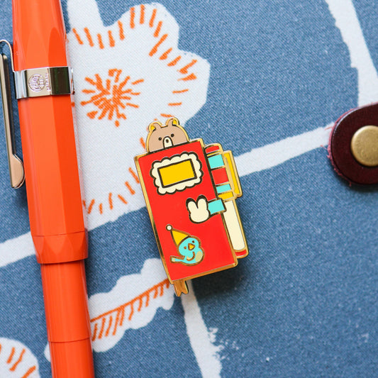 Pin’s émaillé – Journal quotidien